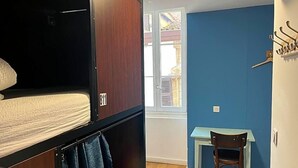 Ein Zimmer mit Etagenbett, Schreibtisch und Stuhl.
