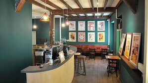 A bar with wooden beams, a counter, and stools. - Hostel 20 Bayonne (Bayonne)