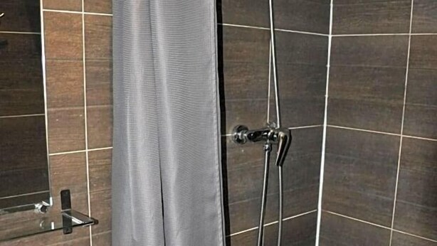 Ein Badezimmer mit Dusche, Waschbecken und Spiegel.