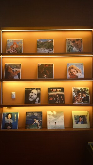 Paret amb diverses prateleires que mostren diferents cobertes d'àlbums de música.