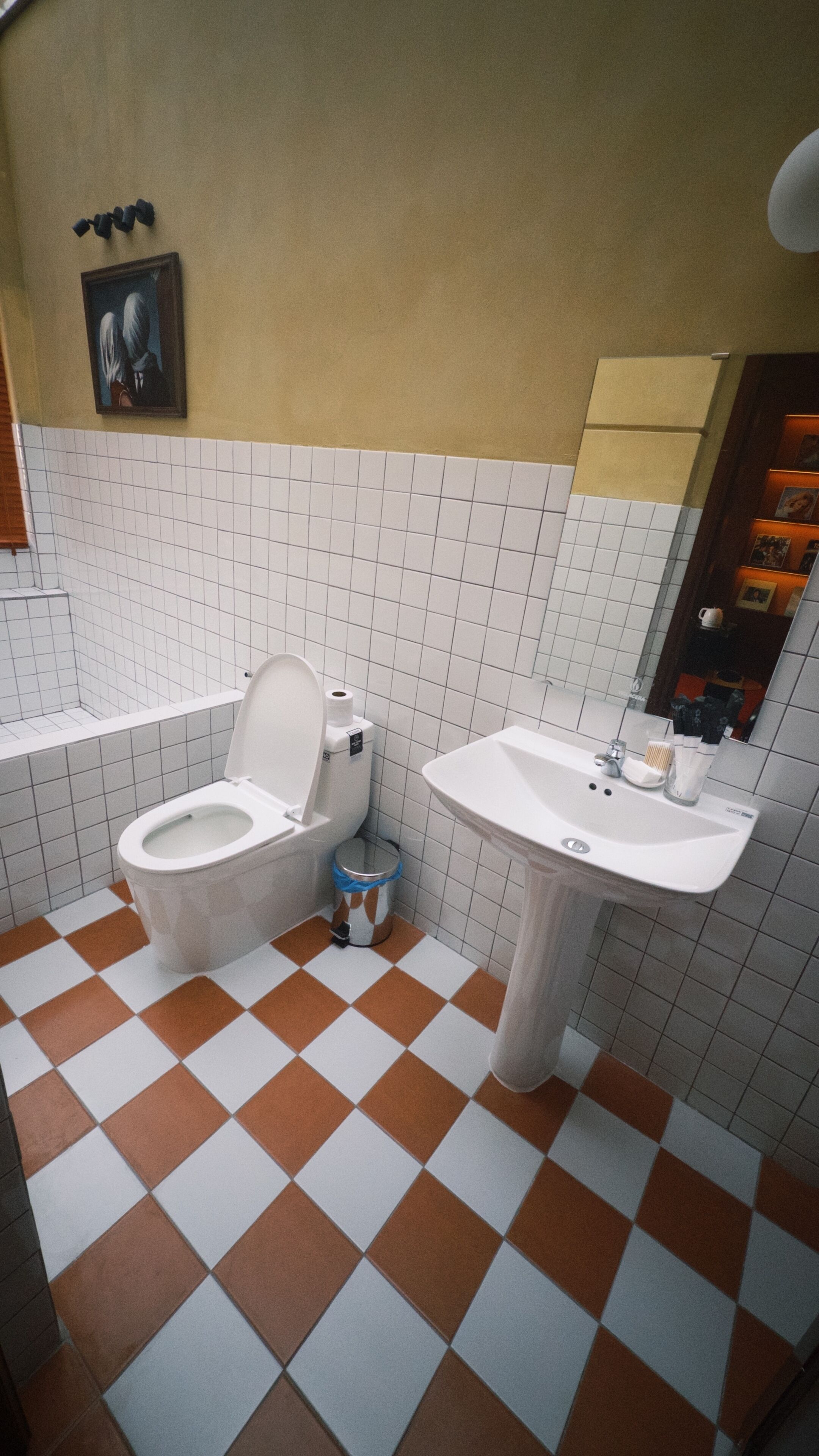 Un baño con inodoro, lavabo y piso de baldosas.