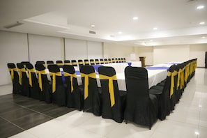 A conference room with rows of chairs, a table, and a whiteboard.