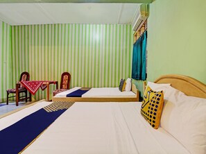 A room with a bed, a chair, a table, and a window with curtains. - Spot On 93182 Hotel Jaya Kusuma (Prambanan)
