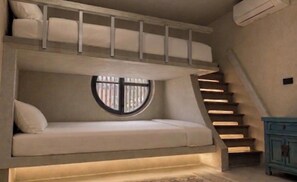 Una litera con ventana, escalones y cómoda.