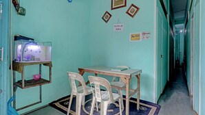 Ein Zimmer mit Aquarium, Tisch und Stühlen sowie ein Gang zu einem anderen Zimmer.