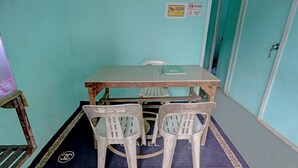 Ein Zimmer mit einem Tisch, zwei Stühlen, einer Tür und einem Schild mit der Aufschrift CCTV-Überwachung.