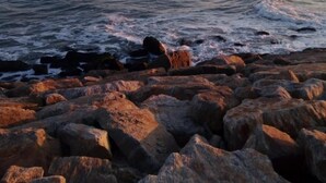 A rocky shoreline with waves crashing onto the rocks. - See U Inn (Murtosa)