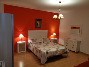 A bedroom with a bed, two bedside tables with lamps, a dresser, a mirror, and a red accent wall. - Hotel Mesv N El Nv Mero Uno (Antequera)