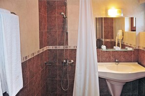 A bathroom with a shower, a sink, and a mirror. - Hotel Real (Plovdiv)