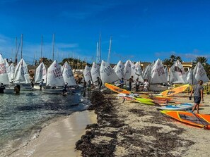 Segelboote liegen an einem Strand bei blauem Himmel.