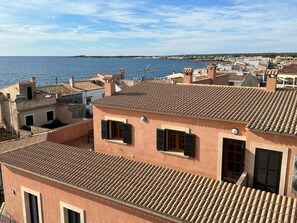 A coastal residential area with terracotta-tiled rooftops and a view of the sea. - Hostal Ca N Pep (Campos)