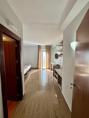 A hotel room with a bed, a desk, and a bathroom door. - El Eden (El Ejido)