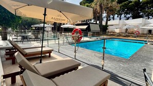 A poolside area with lounge chairs, umbrellas, and a lifebuoy. - El Eden (El Ejido)
