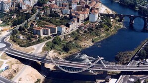 Luchtbeeld van een brug over een rivier, met gebouwen en wegen.