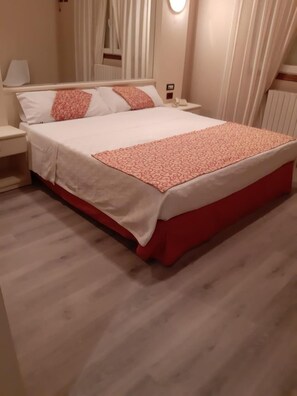 A hotel room with a bed, nightstands, a lamp, and a window with curtains. - Motel Cancun Barbadas Ourense (Barbadas)