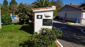A sign for a motel with a clear view of the surrounding area, including a road and greenery. - Motel Cancun Barbadas Ourense (Barbadas)