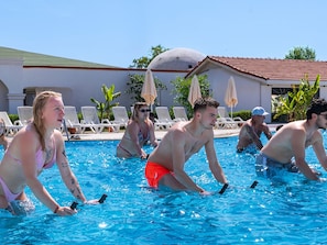 Zona de piscina amb gandules i ombrel·les.
