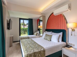 A hotel room with a bed, bedside table, lamp, air conditioning unit, and a view of the outdoors. - La Benata Beach Hotel (Manavgat)