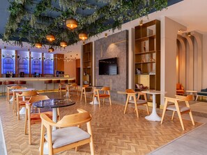 A modern interior with wooden furniture, a bar area, and a TV mounted on the wall. - La Benata Beach Hotel (Manavgat)