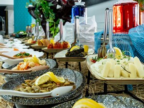 Un buffet proposant une variété de plats et d'ustensiles.