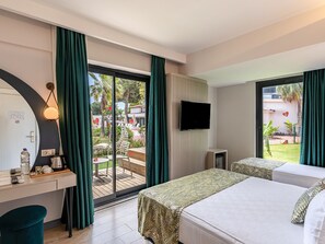 A hotel room with a desk, a bed, a TV, and a sliding glass door to the outside. - La Benata Beach Hotel (Manavgat)