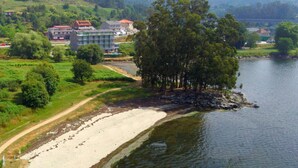 Una propiedad frente al lago con playa de arena, un camino y un edificio de varios pisos.