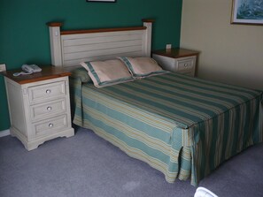 A bedroom with a bed, two nightstands, a telephone, and a painting on the wall. - Las Islas (Vilaboa)