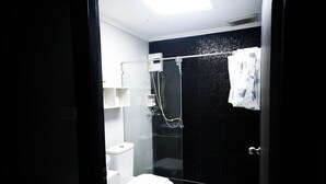 Un bagno moderno con box doccia in vetro, un water e una vasca da bagno.