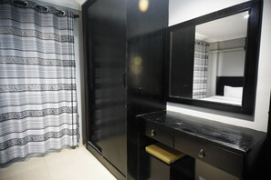A room with a black wardrobe, a mirror, and a striped curtain. - Golden Star Pattaya By Zuzu (Pattaya)