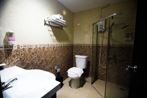A bathroom with a white sink, a toilet, and a glass-enclosed shower. - Golden Star Pattaya By Zuzu (Pattaya)