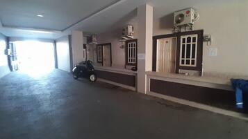 A spacious indoor area with a scooter parked, a ceiling fan, and a door with a window.