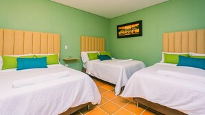 A hotel room with two beds, each with a headboard, a small bedside table, and a wall-mounted picture. - Bamba Hotel Guatapa (Guatapé)