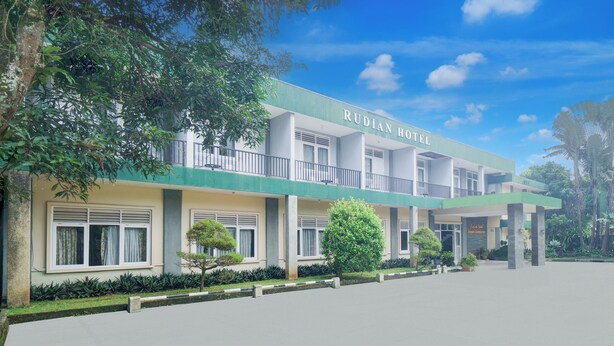 A hotel with a green and white facade, multiple windows, and a well-maintained garden area. - Hotel O Bogor Near Taman Safari (Cisarua)