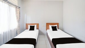 A hotel room with two single beds, a window with curtains, and a tiled floor. - Hotel O Bogor Near Taman Safari (Cisarua)