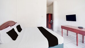 A hotel room with a bed, a desk, a television, and a wardrobe. - Hotel O Bogor Near Taman Safari (Cisarua)