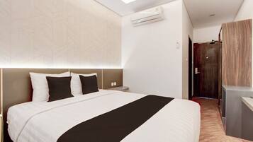 A modern hotel room with a large bed, a desk, and a walk-in closet.