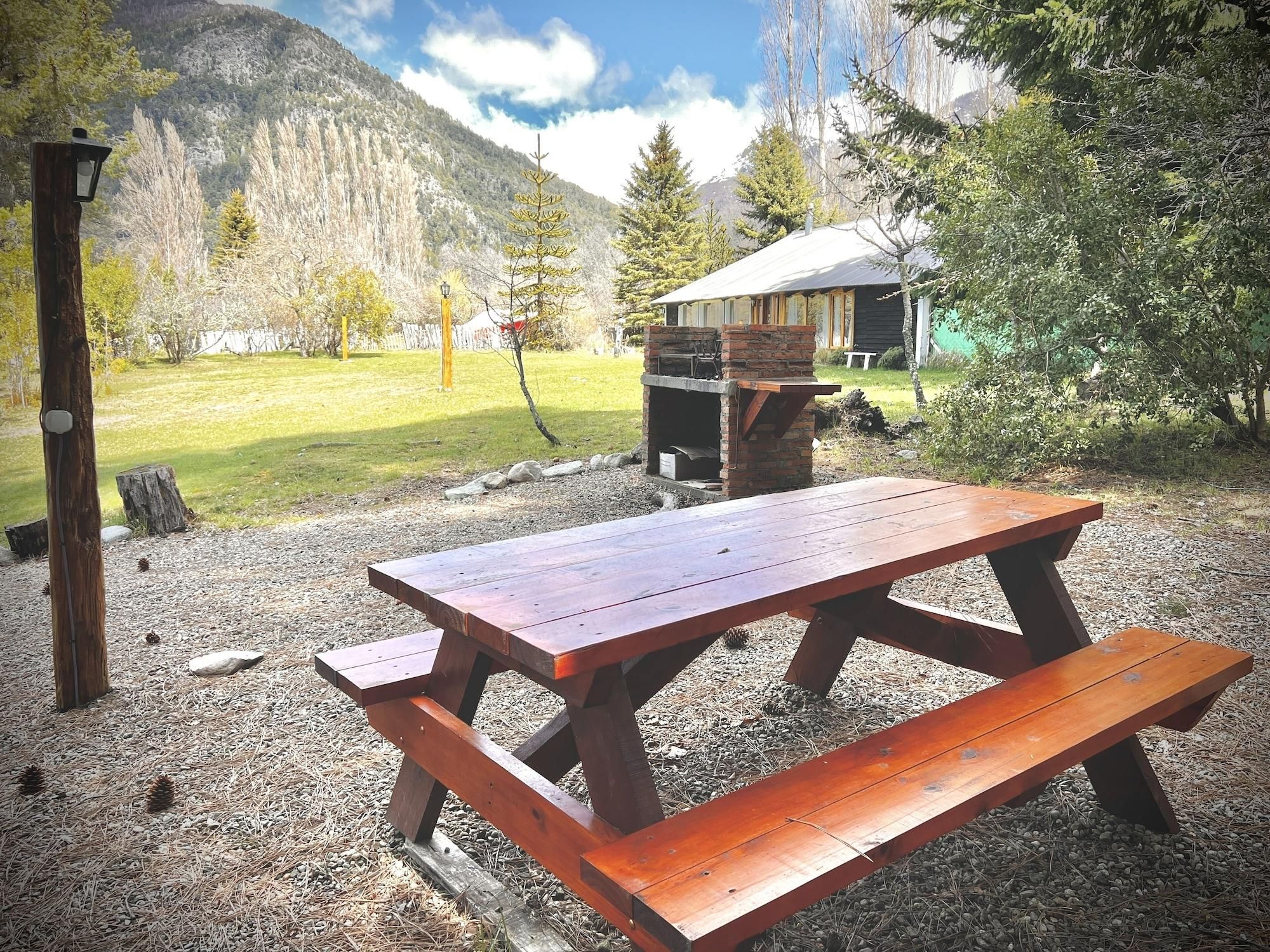 A picnic table in a natural setting with a mountain backdrop.