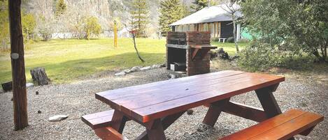 A picnic table in a natural setting with a mountain backdrop.