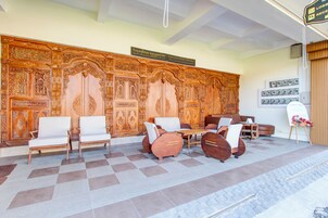 Uma área de recepção com piso xadrez, balcão de atendimento e espaço de espera com cadeiras e sofás.