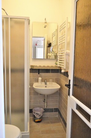 A compact bathroom with a shower, sink, and toilet. - B B Al Golfo (Salerno)