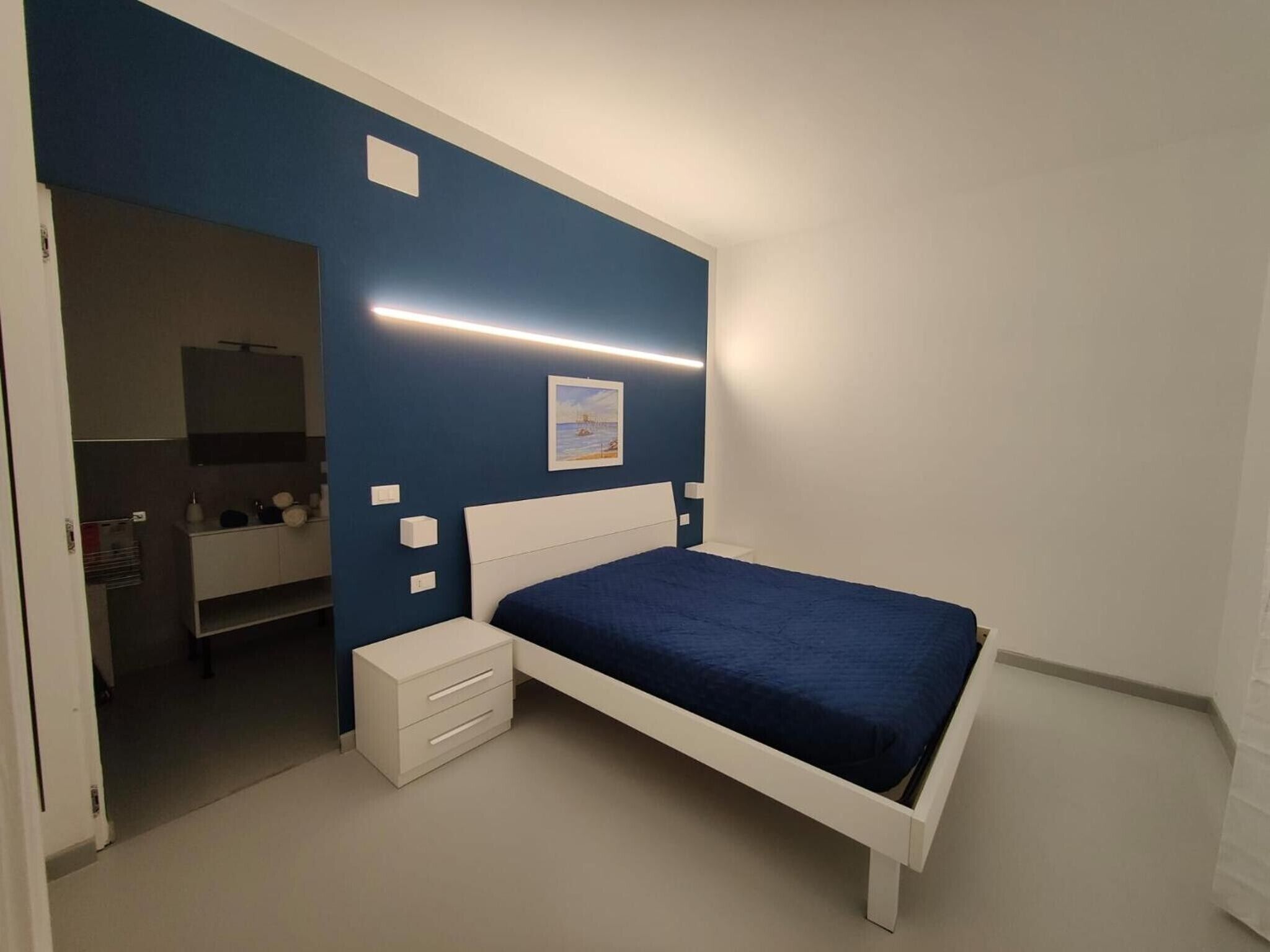Una camera da letto con un letto, comodini, un armadio e uno specchio.