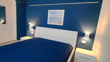 Ein Schlafzimmer mit einem Bett, Nachttischen und Wandleuchten.