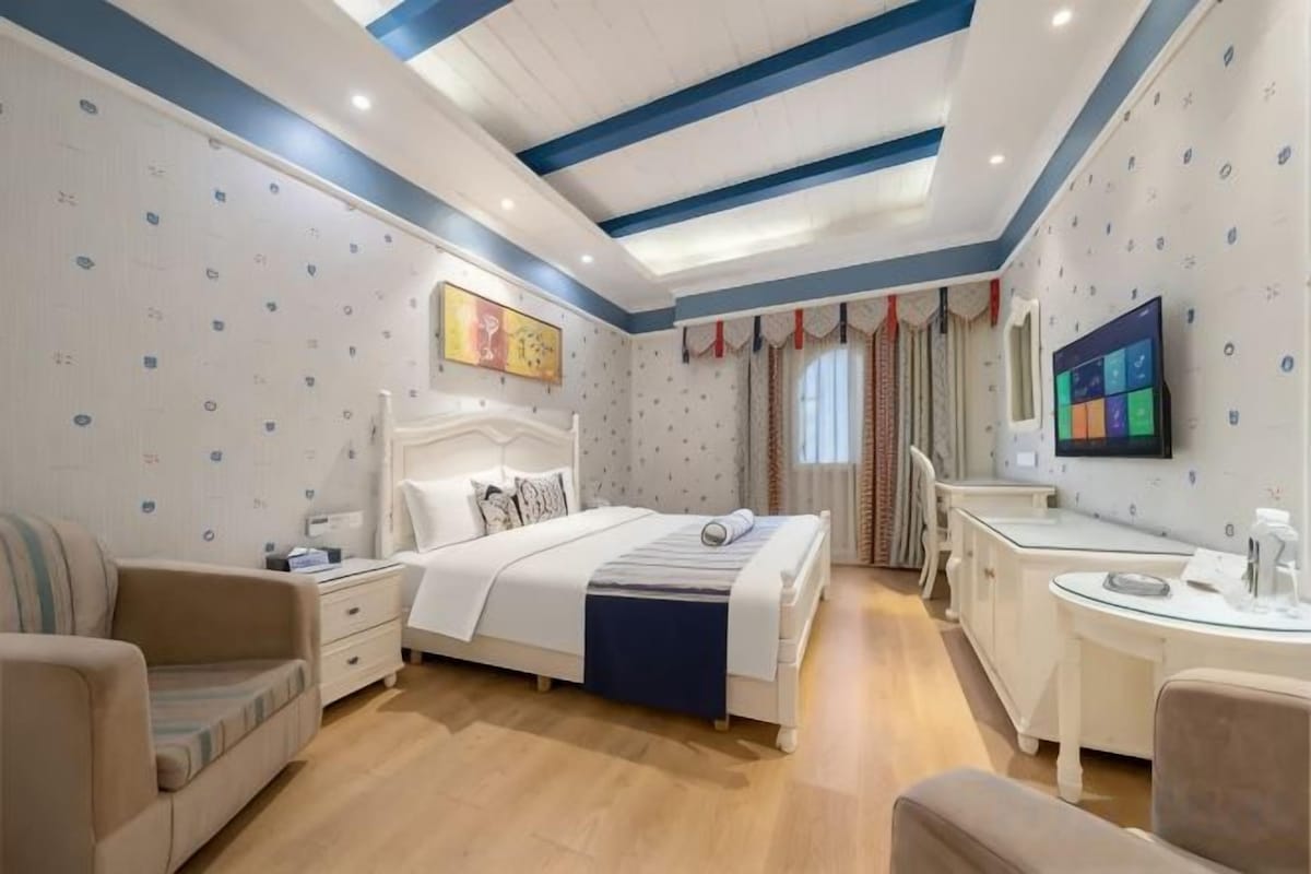 A bedroom with a bed, bedside tables, a desk, and a chair.