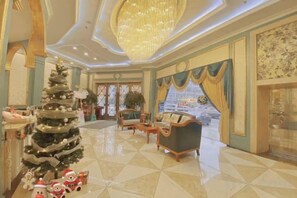 A lobby with a Christmas tree, seating area, and a chandelier. - Youjia Traders Hotel (Pengzhou Longxing Temple) (Chengdu)