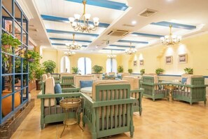 A hotel lobby with green upholstered seating, chandeliers, and potted plants. - Youjia Traders Hotel (Pengzhou Longxing Temple) (Chengdu)