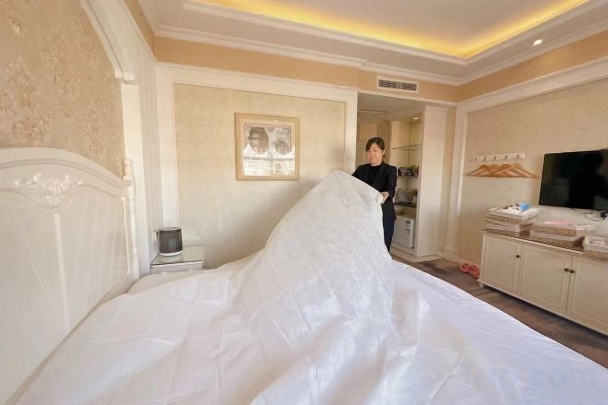 A hotel room with a bed, a television, and a wardrobe.