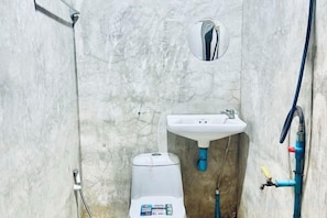 A bathroom with a white sink, a mirror, and a toilet. - A.P.guest house koh mak (Ko Mak)