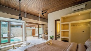 A modern bedroom with a large bed, a ceiling fan, and a view of a swimming pool. - Aozora Villas Uluwatu (Uluwatu)