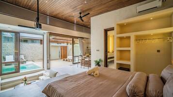Quarto moderno com uma cama grande, um ventilador de teto e vista para uma piscina.