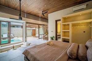 A modern bedroom with a large bed, a ceiling fan, and a view of a swimming pool. - Aozora Villas Uluwatu (Uluwatu)